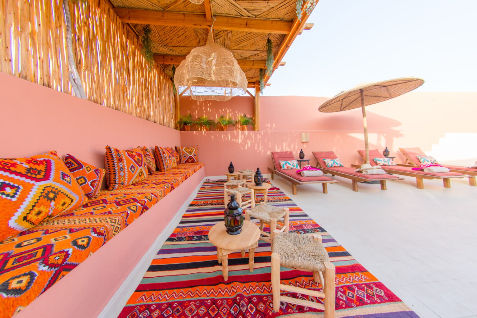 Le salon d'été de la terrasse, banquettes et tapis berbères sous la pergola